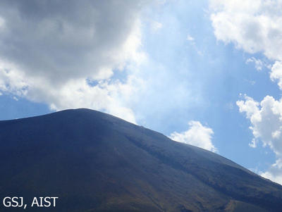 写真１　北東側六里ヶ原からの浅間山（2019年8月8日15時頃）。山頂から右上にうっすらと噴煙が認められます。