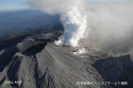 Figure 2-A. Image photographed at 16:36 JST on September 28:This is an aerial view showing the crater in the Kengamine summit area from the northwest. The almost white volcanic smoke is flowing south-southeast. The volcanic smoke in the foreground is from the fissure crater at the western end of the line of craters formed by the recent eruption, while the more distant volcanic smoke is from the line of craters formed in Jigokudani.