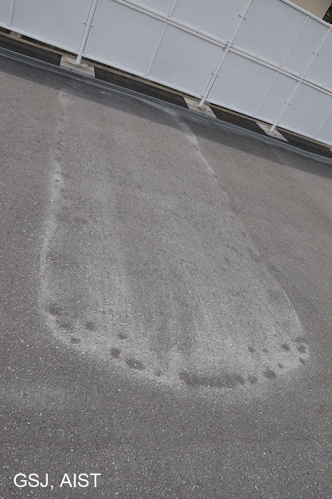 写真4：遠方で確認された降灰の痕跡。10月8日の降雨のため洗い流されているが、駐車場などに痕跡が残されている。由布市庄内町では最大粒径1-2mm程度の火山灰を採取することができた。