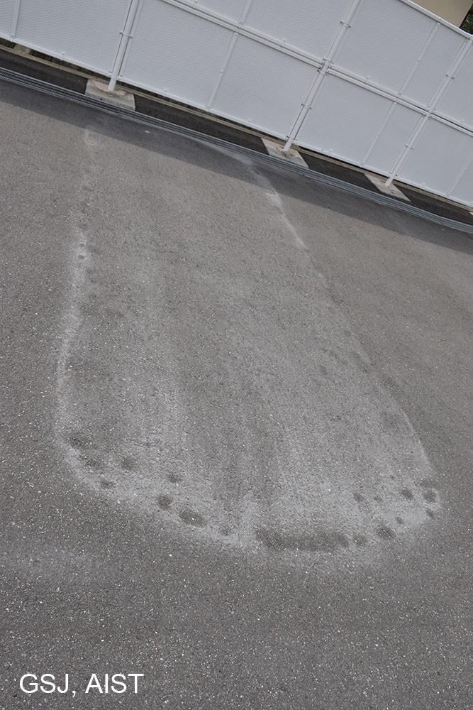 写真4:遠方で確認された降灰の痕跡。10月8日の降雨のため洗い流されているが、駐車場などに痕跡が残されている。由布市庄内町では最大粒径1-2mm程度の火山灰を採取することができた。